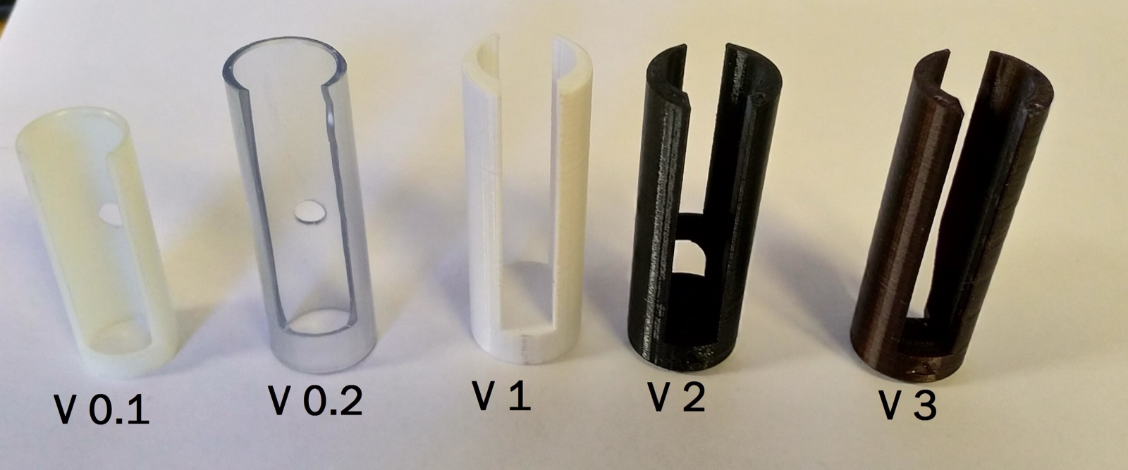 Five tube inserts in a row, hand-labelled V 0.1 to V 3, the first two closed cylinders and the last three split open down one side